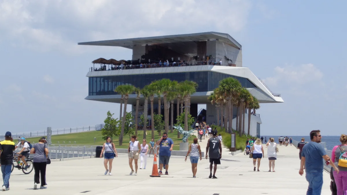 Visitors walk toward the modern St. Pete Pier beside Tampa Bay